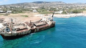 Video from above. Aerial view of sea coast. Flying over coastline with broken ship. Mediterranean Sea and the coast. Shooting from the drone. Cyprus.