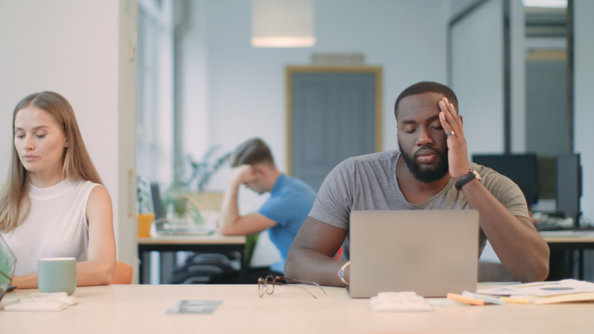Sleepy man sleeping at workplace. Tired guy almost falling down from chair. Boring man trying to work at coworking. Slipping man rubbing eyes in business office. Royalty-Free Stock Footage #1031923739