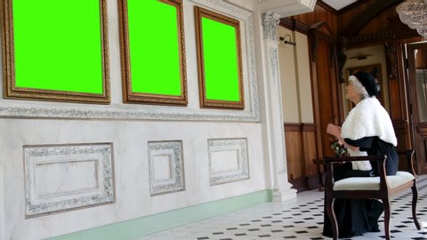 Rich old lady in elegant clothes visiting art gallery. Green screen, slow motion, chromakey
