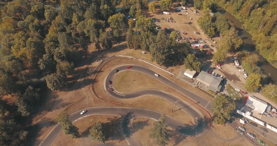 Aerial Drone Shot Pushing In on Multiple Race Cars Drifting Around a Race Track.