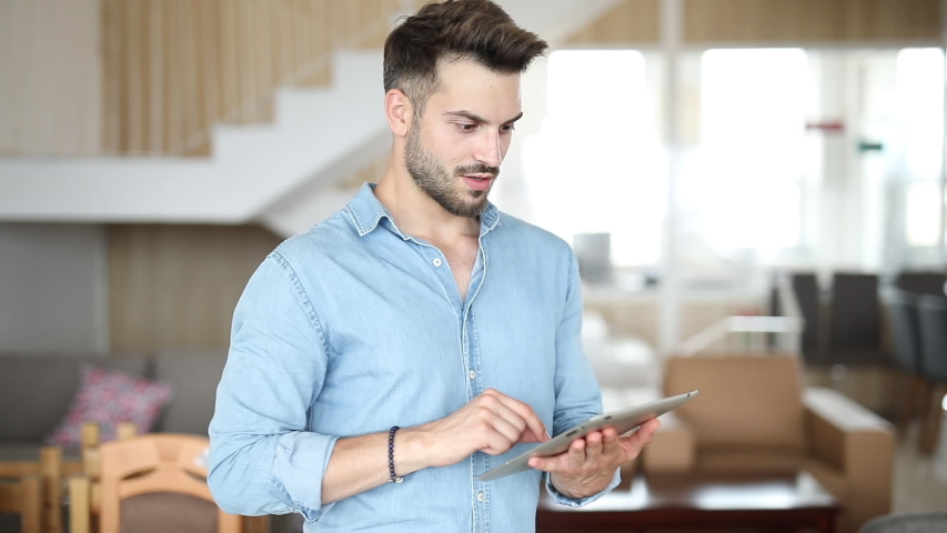Happy casual man anticipates a big win while working on his tablet and celebrates after the good news come in | Shutterstock HD Video #1031937326