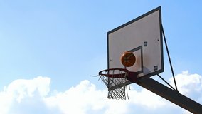 Basketball ball making points in the net during an outdoor match in a sunny day - Real Time in 4K
