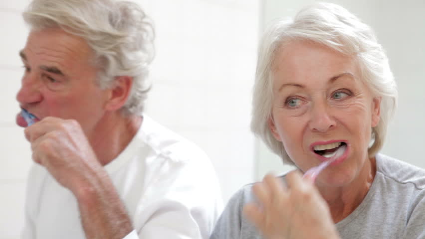 Senior couple brushing their teeth in bathroom mirror pausing to check they are clean. Shot on Canon 5d Mk2 with a frame rate of 30fps | Shutterstock HD Video #10319432