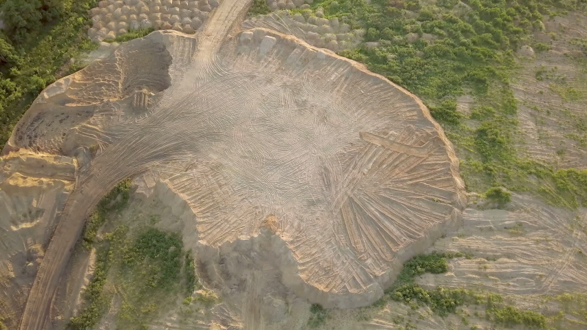 Construction site on a summer evening at sunset. Place for building with earthen embankment. Aerial view. Artificial plateau of sand in the wasteland