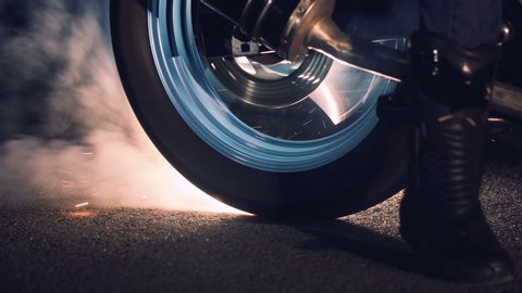 Close up of a motorcycle wheel burning rubber. Smoke and sparks from under the wheels of a sport motobike.