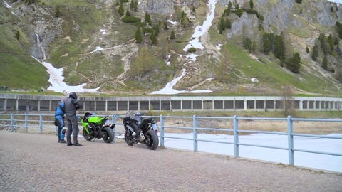 Trento, Italy - May 1, 2019: Motorbikers travelling in Trento Region near Lago di Fedaia covered with snow on May 1, 2019 in Trento region, Italy