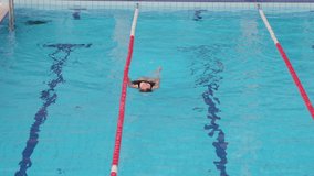 Girl swimming in an indoor pool, casually floating in the water - Powered by Shutterstock - Get 15% off with code: PIKWIZARD15