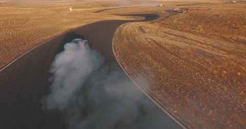 Aerial Drone Tracking Shot Following Race Cars Drifting on a Dessert Racetrack.