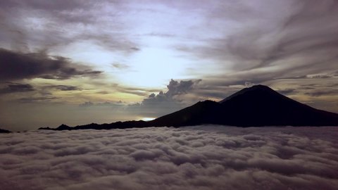Static Aerial shot of Mt. Agung silhouette from Drone flying above a layer of clouds