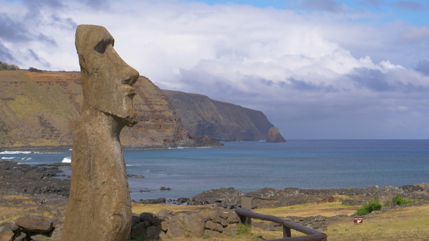 AERIAL, COPY SPACE: Spectacular view of a towering moai sculpture on a remote exotic island in Chile. Breathtaking aerial shot of the deep blue ocean behind a large monolithic statue with a human face