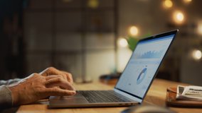 Close-up On the Hands of the Male Specialist Opening Laptop Computer and Starting Working, Screen Shows Various Data and Statistics. In the Background Evening in the Stylish Studio Office - Powered by Shutterstock - Get 15% off with code: PIKWIZARD15