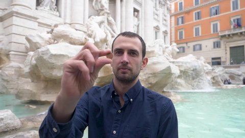 Tourist Tossing Coin Over Shoulder Into Trevi Fountain. Slow Motion.