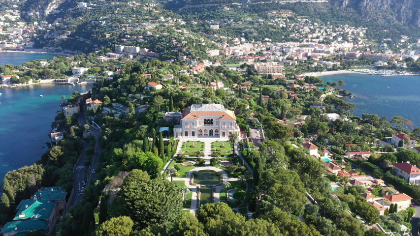 Aerial back traveling over Saint Jean Cap Ferrat south of France amazing paradise mediterranean residential area. Sunny morning Royalty-Free Stock Footage #1031977043