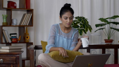 Smiling young Indian woman working from home on her laptop - office work. Work from home concept