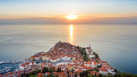 4K. Sunset over old city Piran, aerial panoramic view with old houses, Tartini Square, St. George's Parish Church and marina. Time Lapse video.
