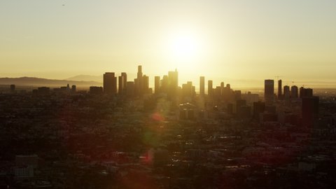 Aerial cityscape view with sun flare central Los Angeles and sunrise over financial district skyscrapers California USA