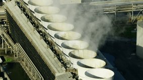 Aerial view steam emissions oil refinery cooling towers with rotating fans producing greenhouse gasses Los Angeles California USA - Powered by Shutterstock - Get 15% off with code: PIKWIZARD15
