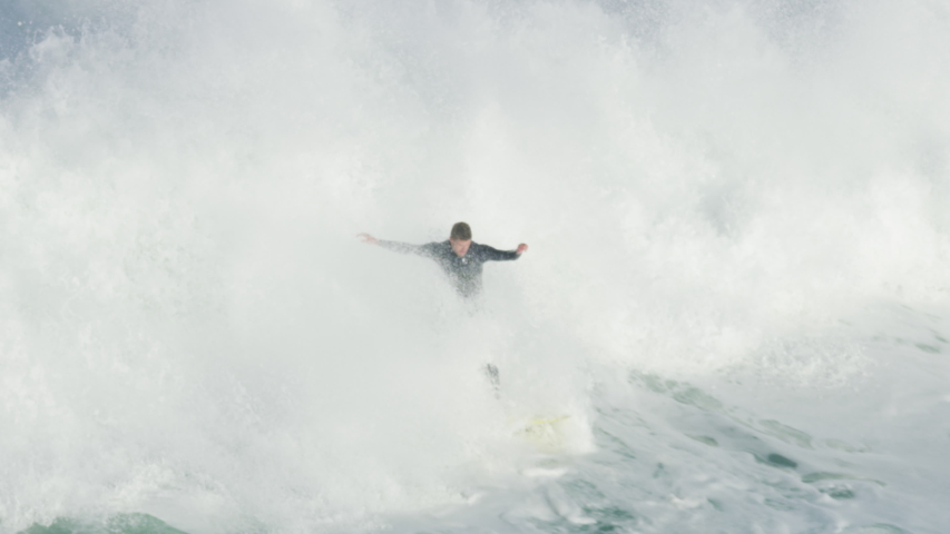 Aerial view of confident athletic surfer riding big wave on surf competition Mavericks Pillar Point Harbor California USA RED WEAPON