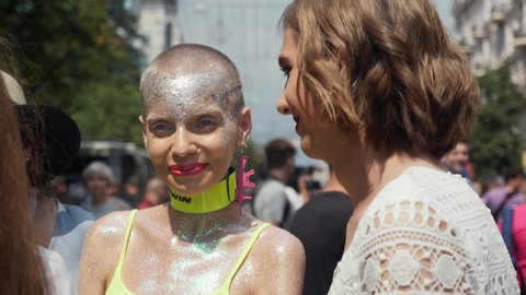 Kiev/Ukraine-June, 23 2019 Young LGBT couple talking and smiling at Gay Pride Parade. Close-up view of attractive lesbian with cut short hair