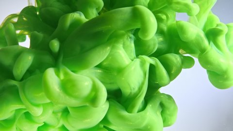Green color paint drops in water against white background.: stockvideo