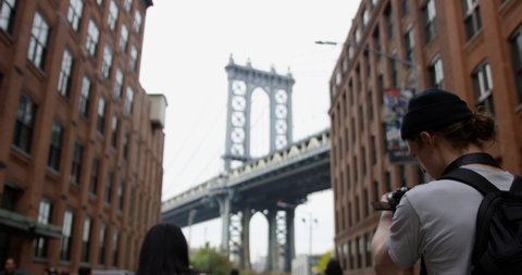 Trendy Photographer Taking Beautiful Photographs Iconic Manhattan Bridge in The Beautiful Dumbo Brooklyn In the Infamous New York City With Tourists Experiencing The City.