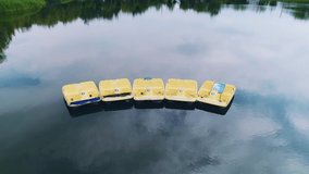 Flying over pedal boats on lake water, aerial panoramic video. 4K.
