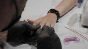 Professional manicurist man rubs his feet with an anesthetic cloth.