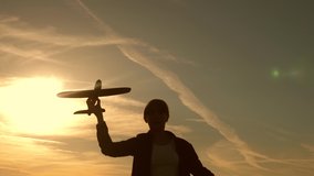 Children on background of sun with an airplane in hand. girl play with a toy plane at sunset. Dreams of flying. Happy childhood concept. Silhouette of children playing on plane - Powered by Shutterstock - Get 15% off with code: PIKWIZARD15