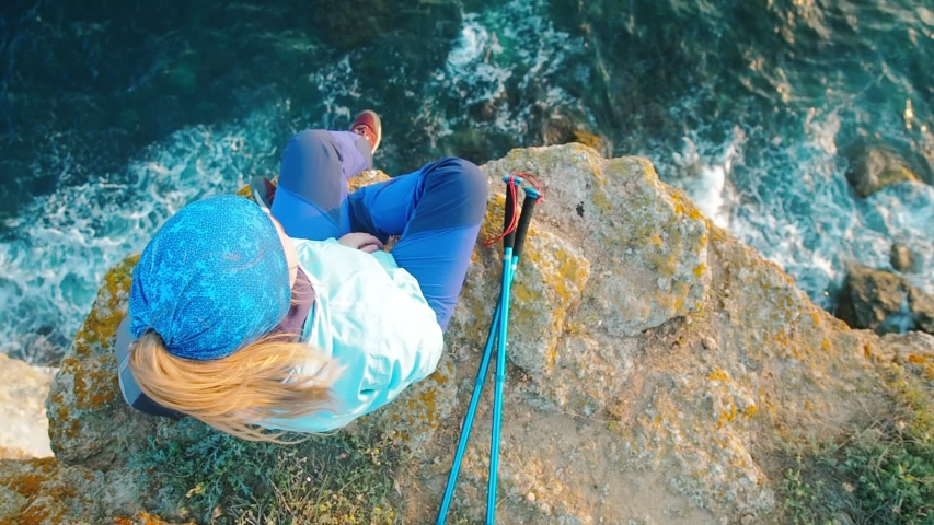 Young active girl travel summer sea shore. Woman sitting on the cliff, enjoying view of sea waves at sunset. Hiking and trekking concept, people outdoor. | Shutterstock HD Video #1032065882