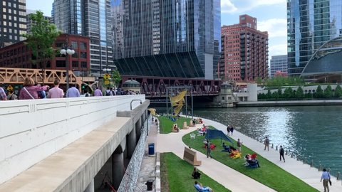 Chicago, IL / USA - 6/13/19: Chicago's upper and lower city, with view of Upper Wacker Drive and the riverwalk below. Contrasting view where commuters hurry and tourists find leisure.