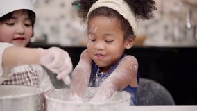 Slow motion - Group of children baking cake together in classroom, Multi-ethnic young boys and girls happy making dessert cooking in kitchen at school. Kids cooking at school concept. - Powered by Shutterstock - Get 15% off with code: PIKWIZARD15