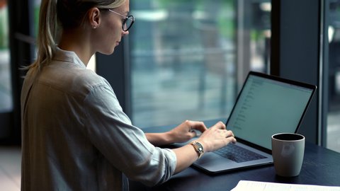 Young millennial woman typing text information for sending email to colleague via application on modern laptop computer, skilled it professional working remotely with initializing process for database