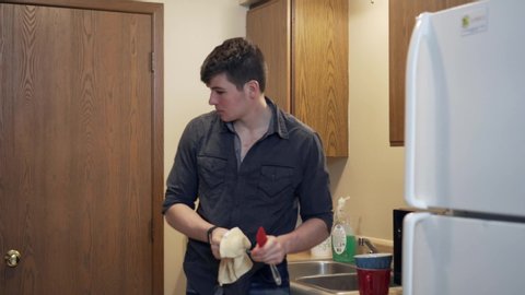 Person putting dishes in cupboard. 4k. Shallow depth of field.