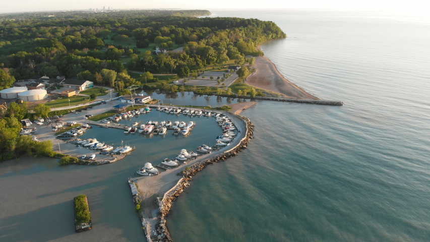 Fly over aerial view of the Michigan lake shore line, pier, yacht club, boats, summer, sunny morning