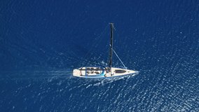 Aerial drone tracking video of luxury sail boat cruising deep blue open ocean sea