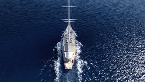 Aerial drone tracking video of luxury sail boat cruising deep blue open ocean sea