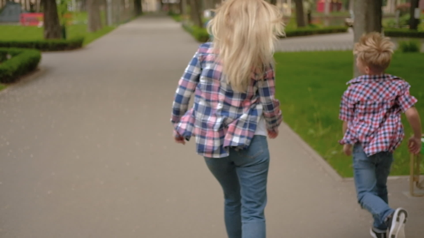 Joyful family leisure. Mom and son having fun in park playing tag