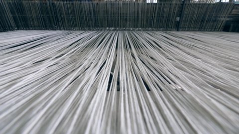 Thick white threads are getting sewn in a close up. Textiles Production Line