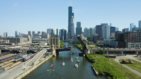 Zoom In - Sailboats pass underneath bridge over Chicago River in South Loop during weekly Chicago Bridge Raise