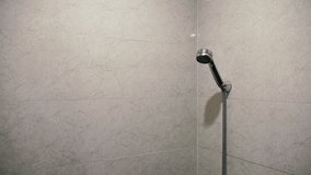 Drops of water from the damaged shower, leak water and rust on the shower tap. Royalty high-quality free stock video footage of damaged leaking water tap hose in the bathroom of house, flat or hotel