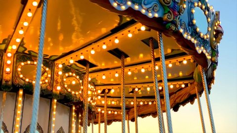 A merry-go-round, or carousel spinning at sunset