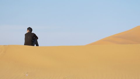 Camel shepherd sitting in Erg Chebbi desert