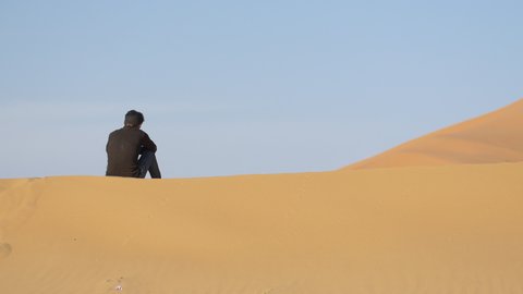Camel shepherd sitting in Erg Chebbi desert