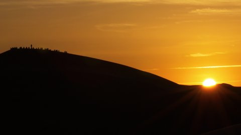 Sunrise over Erg Chebbi desert with tourists