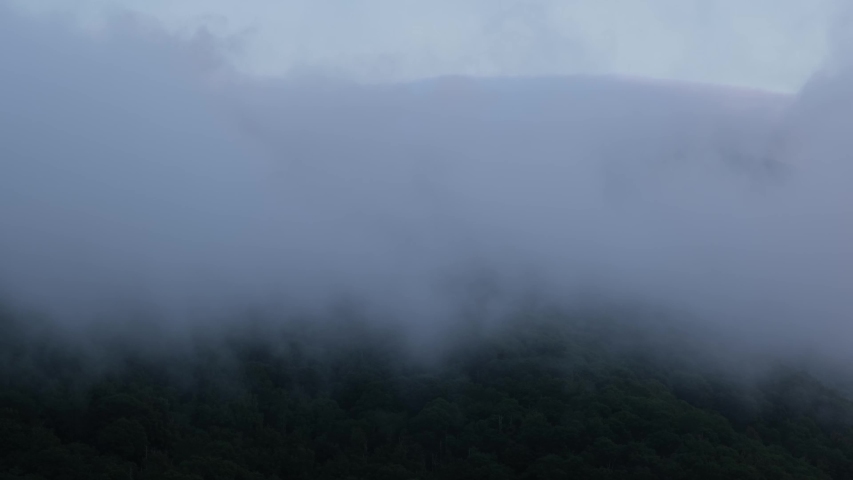 Scenic misty morning view of clouds and fog lifting over the Blue Ridge Mountains near Asheville, North Carolina from the Blue Ridge Parkway, a scenic byway running across the mountains of western NC.