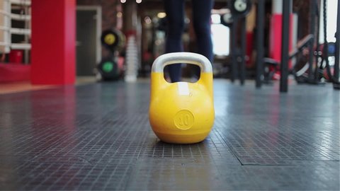 Kettlebell fitness, young female athlete doing strength exercises in the gym