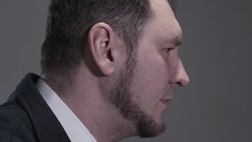 Profile portrait of man in a business suit who reading a rap, sings or quickly says something while actively gesticulating.