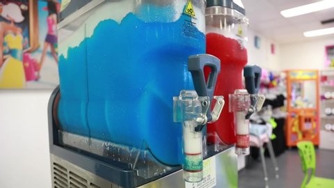 Focused shot of slushy machine blending blue liquid