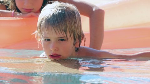 Handsome blonde young boy at the swimming pool, candid