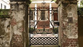 Metal gate in a stone wall against the background of an old house on a sunny day - Powered by Shutterstock - Get 15% off with code: PIKWIZARD15